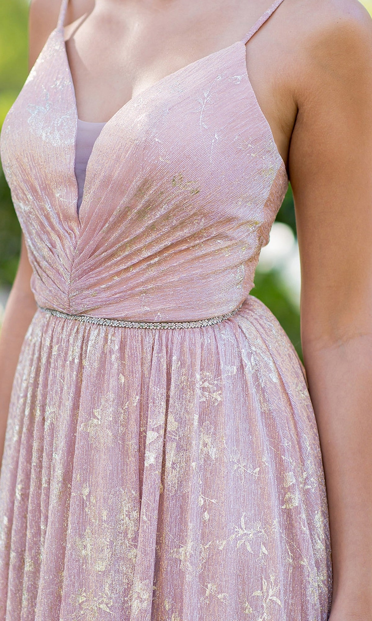 A close-up of a person wearing the Cinderella Couture 8086J blush pink prom dress, featuring a floral print, metallic patterns, and a ruched bodice, shown from shoulders to waist.